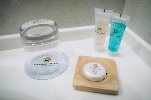 a bathroom counter with two products and a bottle of soap at Hotel Dastan Aktobe in Aktobe
