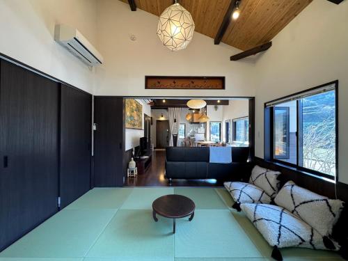 een woonkamer met een tafel en een bank bij IMARI HOUSE shachihoko イマリハウス しゃちほこ in Imari