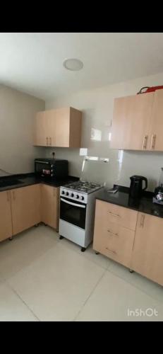 een keuken met een fornuis en houten kasten bij Modern Apartment in Muscat in Muscat