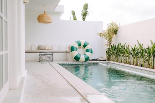 una piscina en una casa con una pelota de playa en Calma Ubud Suite & Villas - Rice Fields View, Infinity Pool !, en Ubud
