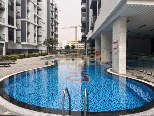 a large blue pool in the middle of a building at Zapbed House-Modern Studio-Petalz By Danube in Dubai