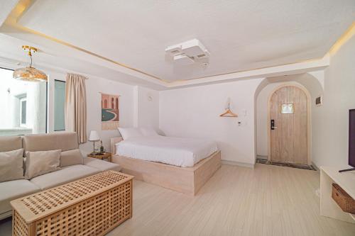 a living room with a bed and a couch at 레이니데이 in Namŭm-ni
