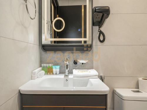 a bathroom with a sink and a mirror and a toilet at Zapbed House-Modern Studio-Petalz By Danube in Dubai
