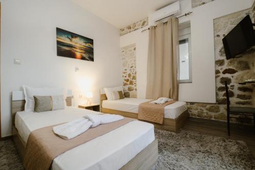 a hotel room with two beds and a tv at luxury house in Ierapetra
