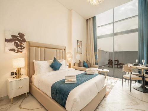 a bedroom with a large bed and a dining room at Zapbed House-Modern Studio-Petalz By Danube in Dubai