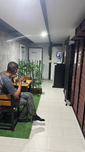 a man sitting at a table looking at his cell phone at Sean Sabai The Secret Room in Ban Na We
