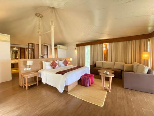 DehegilaMarahai Villa Morotai的带一张大床和一张沙发的卧室