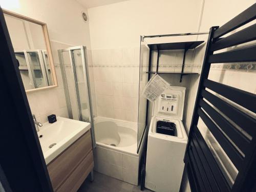 ein kleines Bad mit einem Waschbecken und einer Badewanne in der Unterkunft Appartement agréable à deux pas du plan d'eau in Embrun