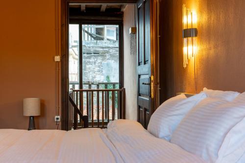 ein Schlafzimmer mit einem weißen Bett und einem Fenster in der Unterkunft Αρχοντικό Παπαγιάννη in Edessa