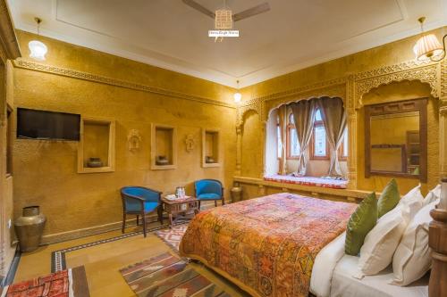 a bedroom with a king sized bed and a tv at Hotel Rugh Niwas in Jaisalmer