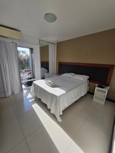 a bedroom with a bed and a large window at Eco Paradise 129 in Caucaia