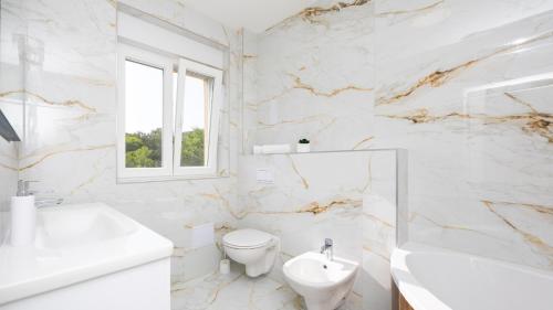 ein weißes Badezimmer mit Toilette und Waschbecken in der Unterkunft Villa Ivan by Villas Guide in Primorski Dolac