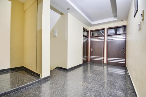 Ein Flur in einem Gebäude mit Türen und Betonböden in der Unterkunft Hotel O Santosh Seva Sadan in Rāiwāla