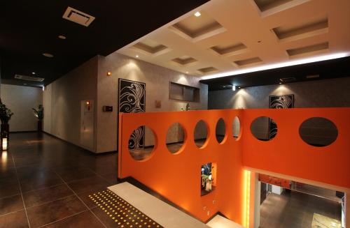 a room with an orange wall with a fireplace at HOTEL W-PREMIUM -W GROUP HOTELS and RESORTS- in Koshigaya