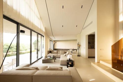 een woonkamer met meubilair en een groot raam bij KW 2 Villa in Ban Bang Po