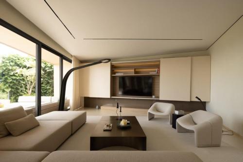 een woonkamer met een bank, stoelen en een tv bij KW 2 Villa in Ban Bang Po