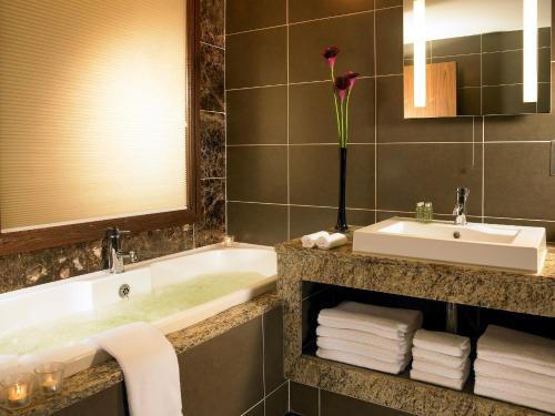 a bathroom with a sink, mirror, and towel rack at Westport Plaza Hotel, Spa & Leisure in Westport