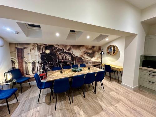 a dining room with a table and blue chairs at The Station at Shustoke - Birmingham Airport & NEC in Shustoke