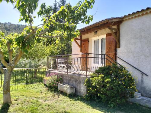 een huis met een balkon en een boom bij Gite emilouise in Carnoules