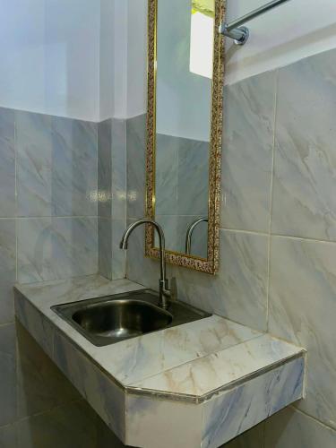 a marble sink in a bathroom with a mirror at Kenji Guest House in San Vicente