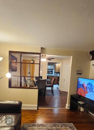 a living room with a television and a dining room at Lansdowne Gem in Lansdowne