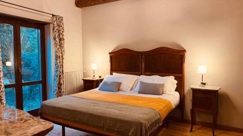 a bedroom with a large bed with a wooden headboard at Pool Villa With Animals Near Sutri in Sutri