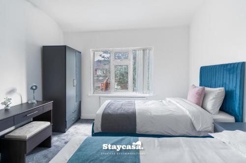 En eller flere senge i et værelse på Spacious 4-Bed Home near Didsbury