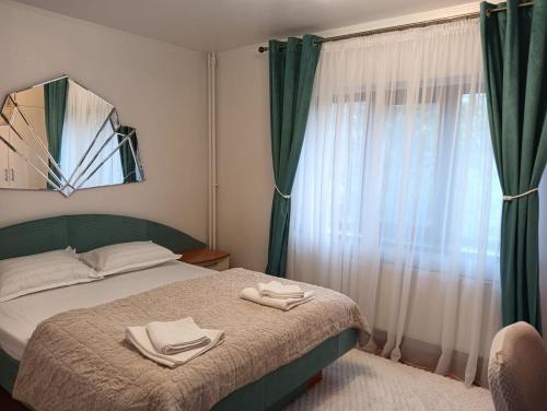 a bedroom with a bed with two towels on it at La Montzi For4 in Craiova