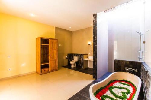 a large bathroom with a tub and a shower at Asri Sari Ubud Resort in Ubud