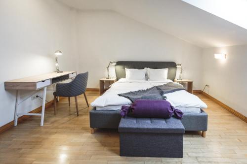 een slaapkamer met een bed en een bureau en een bureau bij Bearsleys Archers Apartments in Rīga