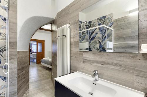 een badkamer met een wastafel en een spiegel bij In Casetta da Mae in Lorenzago