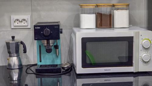 een aanrecht met een magnetron en een koffiezetapparaat bij Confort, propreté et tranquillité à Alger centre in Alger