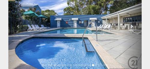 a swimming pool with a slide in a yard at Holiday Home in Footprints in Preston Beach