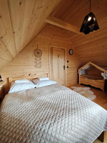 a bedroom with a large bed in a wooden room at Domek z Sercem in Pieniążkowice