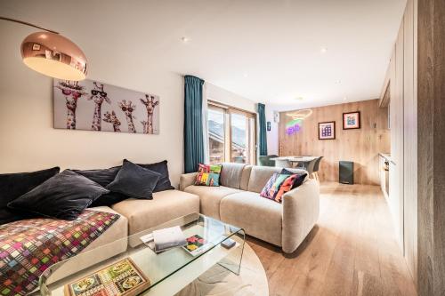 een woonkamer met een bank en een tafel bij Emerald Stay Apartments Morzine - by EMERALD STAY in Morzine