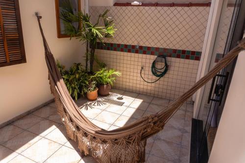 een hangmat in een kamer met potplanten bij Recanto aconchego in Peruíbe