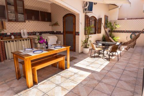 een patio met een houten tafel en stoelen bij Recanto aconchego in Peruíbe