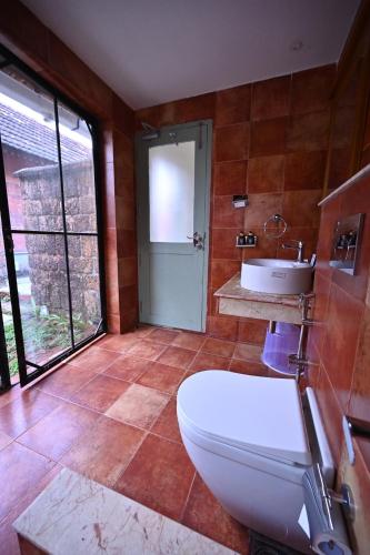 a bathroom with a toilet and a sink at Vedic Village Retreat Alleppey in Alleppey