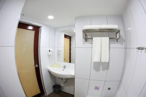 a bathroom with a sink and a mirror at City Garden Hotel in Tawau