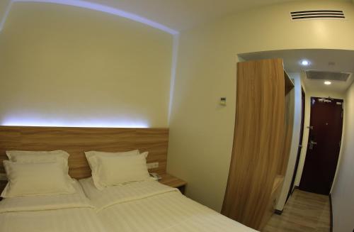 a bedroom with a large bed with white pillows at City Garden Hotel in Tawau