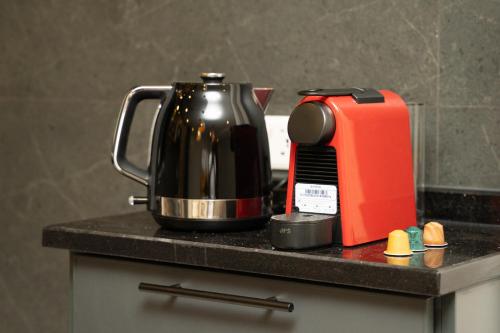 Eine schwarze Arbeitsplatte mit Kaffeekanne und Toaster in der Unterkunft Maria Suites 2 in Aqaba