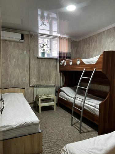 a bedroom with two bunk beds and a chair at Hostel Sulaiman-Too in Osh