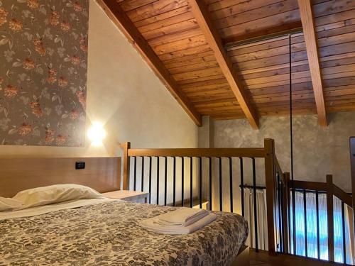 een slaapkamer met een bed en een houten plafond bij Il Poggio Agrisport in Poirino