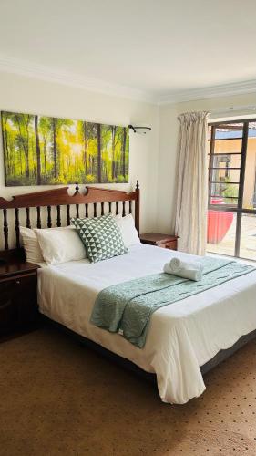 a bedroom with a large bed and a window at The Folkestone Guest House in Gqeberha