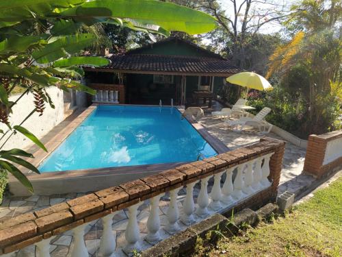 een huis met een zwembad en een hek bij Sítio Refúgio Primavera in Monte Verde