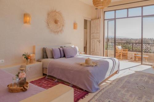索维拉Lalla Essaouira, Villa Najma avec piscine pour 15 personnes的一间卧室，里面有一张床和一扇大窗户。