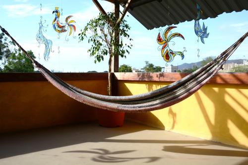 a hammock on a roof with a tree in the background at Tuzco Lodge in Puerto López