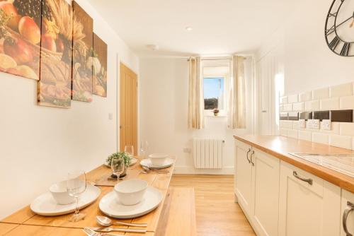 a kitchen with a wooden table with dishes on it at Yeavering - North East Escapes in Wooler