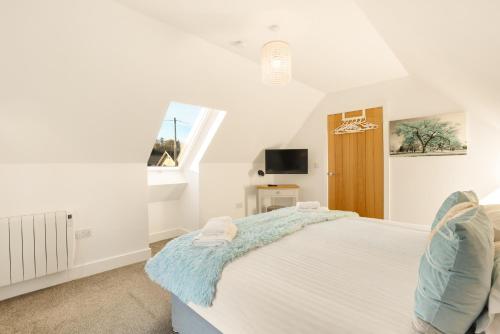 a bedroom with a bed and a tv and a window at Yeavering - North East Escapes in Wooler