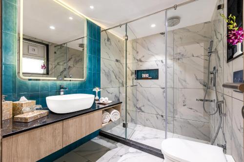 een badkamer met een glazen douche en een wastafel bij Sterling Arka Suites, Puri in Puri